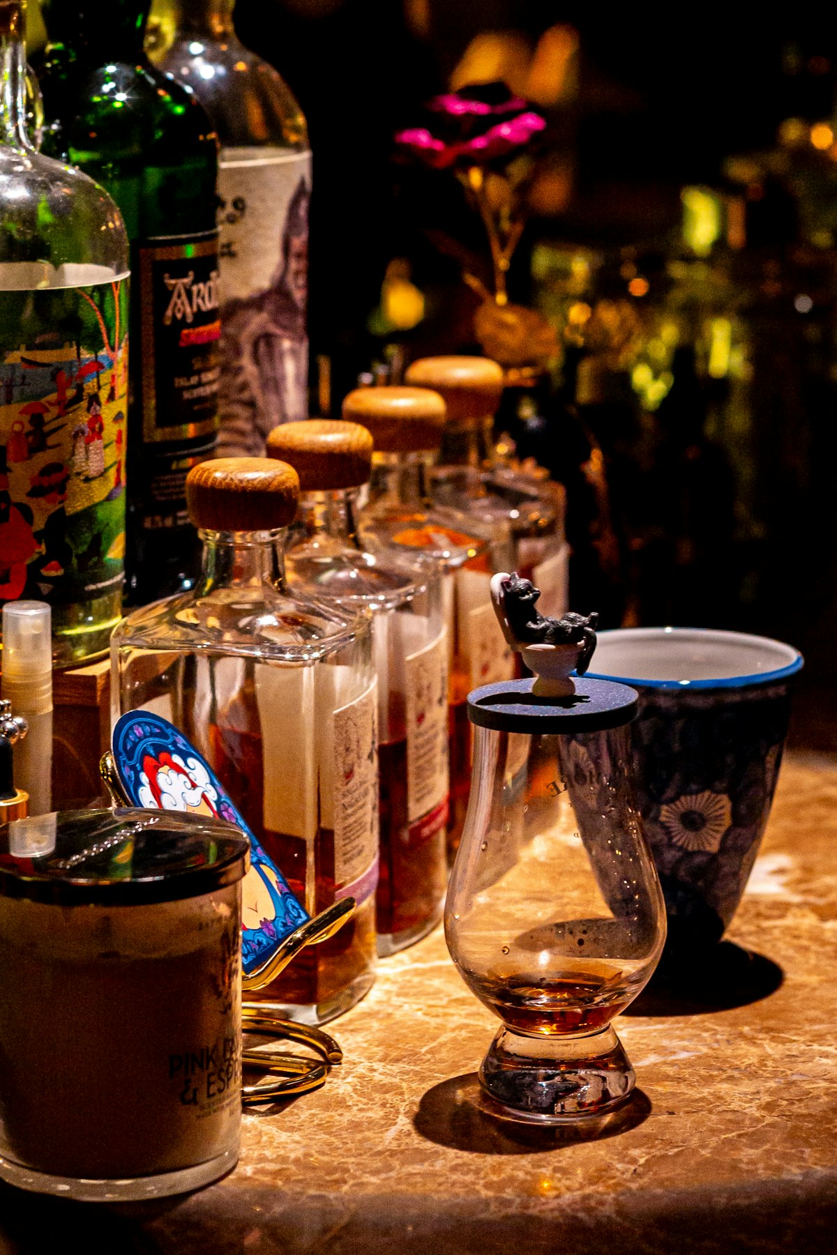 Premium spirits bottles and whiskey glass in a dark bar setting